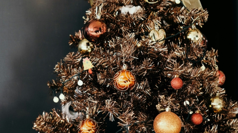 Afbeelding van een vrolijke woonkamer met een prachtig versierde kerstboom. Goedkoop een kerstboom gehuurd.